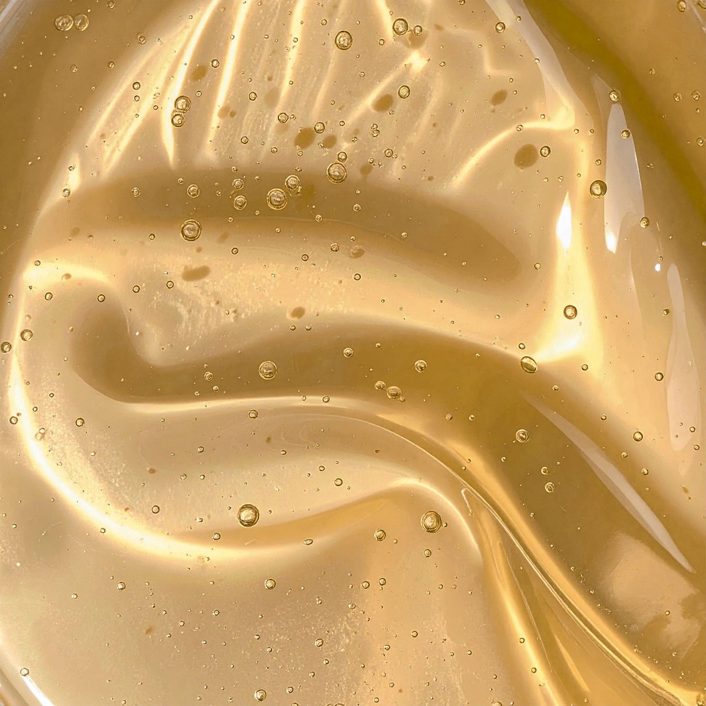 Close-up of golden hair gel texture with air bubbles for natural hair care