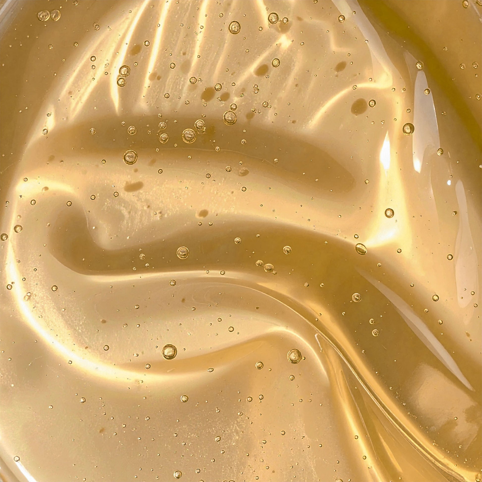 Close-up of golden hair gel texture with air bubbles for natural hair care