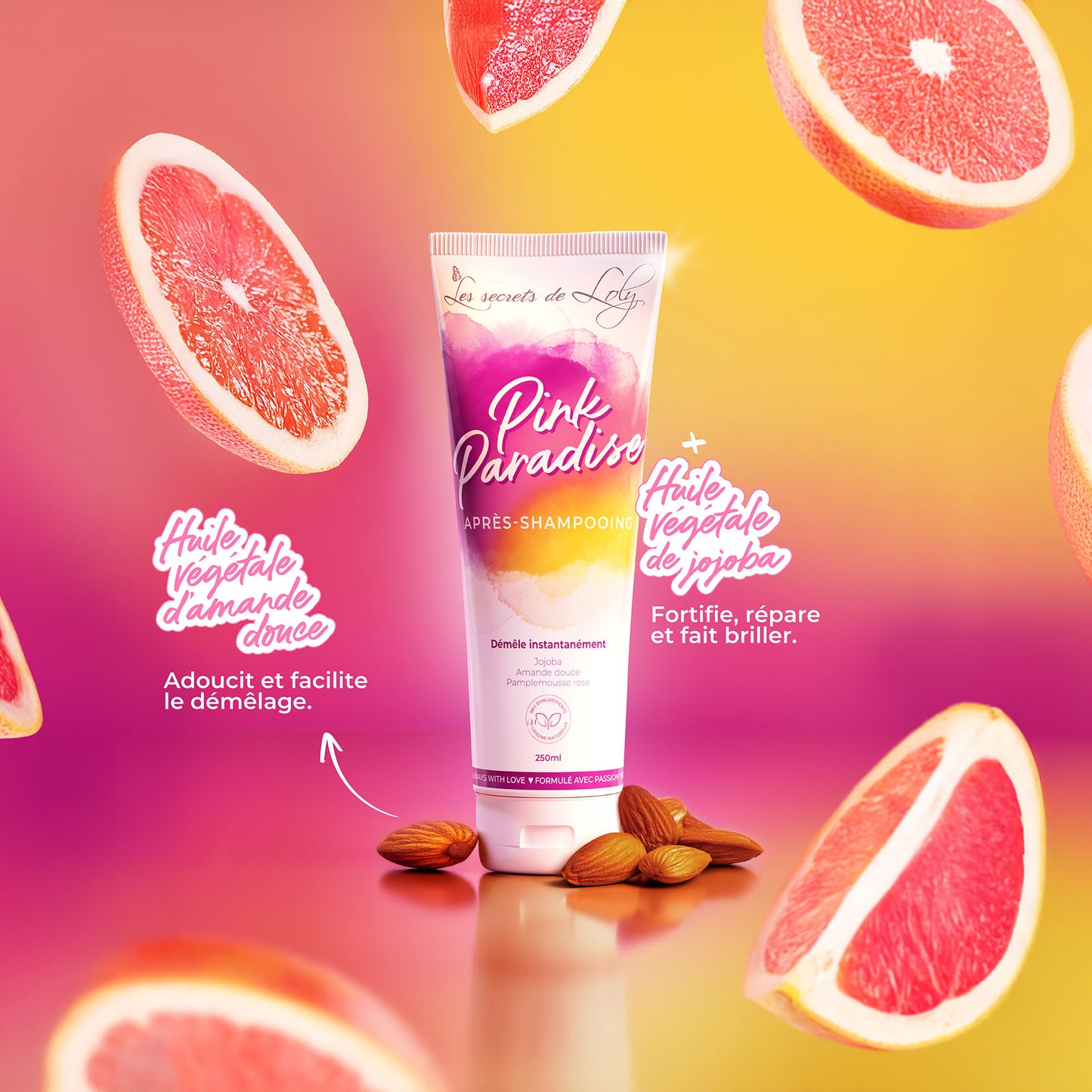 Pink Paradise conditioner tube with almonds and grapefruit slices on colorful background, highlighting natural hair care ingredients.