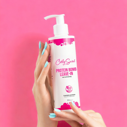 Woman holding Curly Secret Protein Bomb Leave-In conditioner bottle for curly hair care